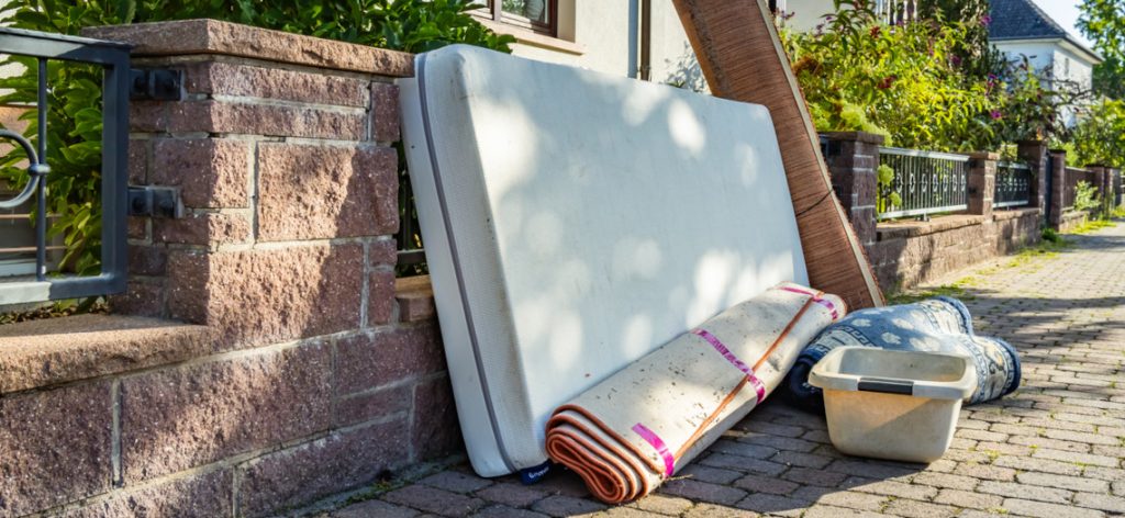 Sperrmüll an einer Mauer auf dem Gehweg
