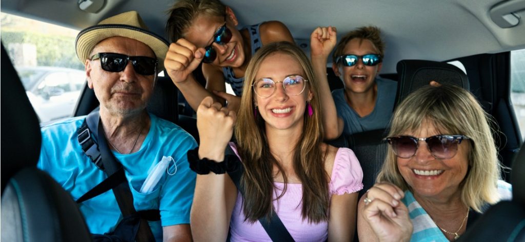 Fünf Personen sintzen eng gedrängt in einem zu kleinen Auto