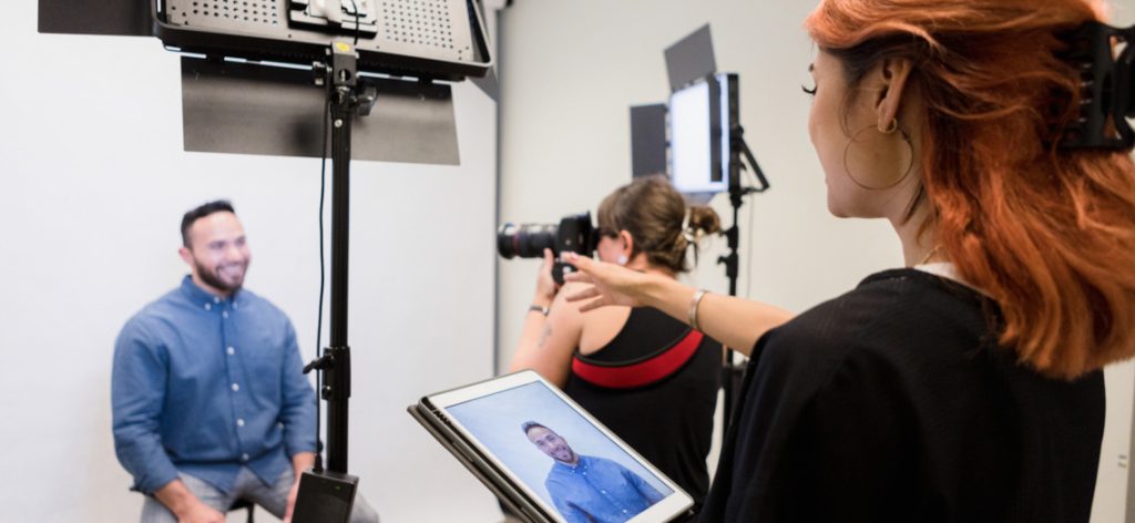 Zwei Fotografinnen machen in Studio ein Passbild von Mann