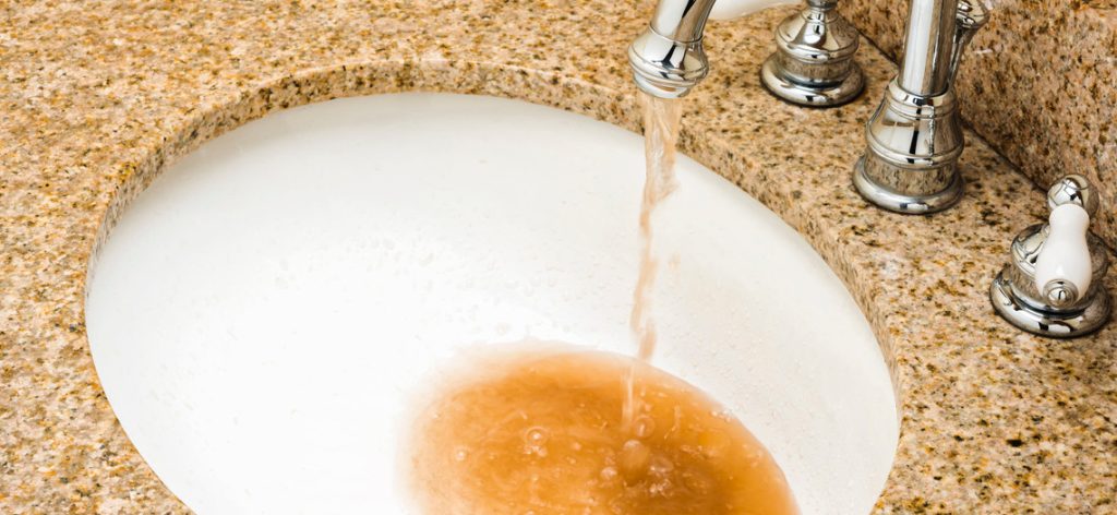 Dreckiges braunes Wasser kommt aus einem Wasserhahn
