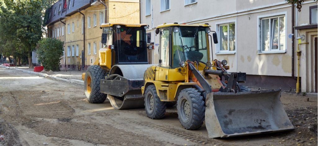 Zwei Bagger auf einer aufgerissenen Straße