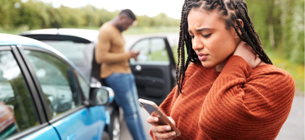 Junges Paar in Autounfall am Handy