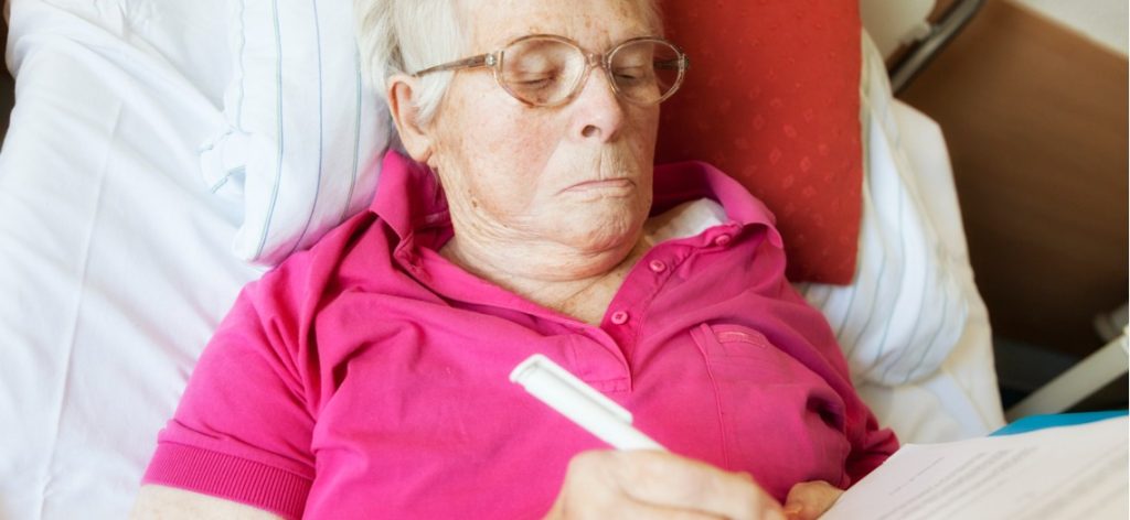 Alte Frau unterschreibt im Krankenhausbett ihr Testament