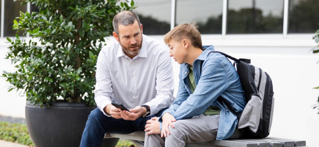 Vater und Sohn führen ein Streitgespräch vor der Schule