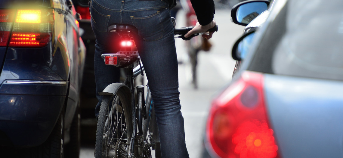 Fahrrad zwischen zwei Autos auf einer Straße