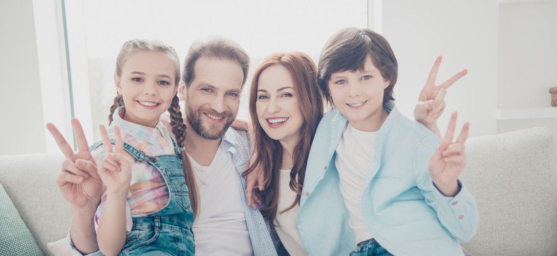 Eltern mit zwei Kindern Victory Zeichen